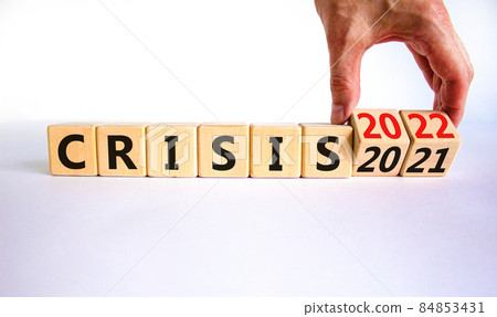 2022 crisis and new year symbol. Businessman turns wooden cubes and changes words 'crisis 2021' to 'crisis 2022'. Beautiful white background, copy space. Business, 2022 crisis and new year concept. 84853431