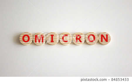 Covid-19 new omicron strain symbol. The concept word Omicron on wooden circles. Beautiful white background. Copy space. Medical and COVID-19 new omicron strain variant virus concept. 84853433