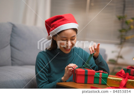 happy woman wrapping gift box on table happy woman wrapping gift box on table 84853854