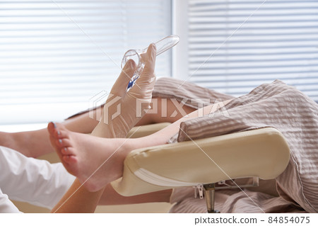 Gynecologist holding a mirror for vaginal examination of the patient 84854075