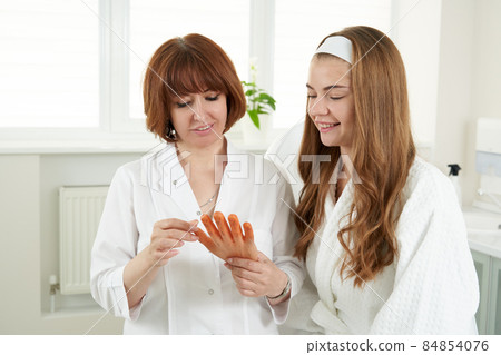 Doctor holding artificial hand. Young woman having an acupuncture treatment therapy on hand in spa salon. Alternative medicine concept. Doctor holding artificial hand. Young woman having an acupuncture treatment therapy on hand in spa salon. Alternative medicine concept. 84854076