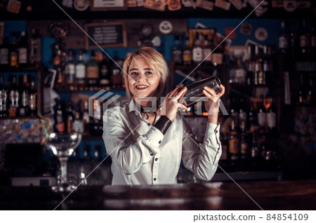 Girl barman mixes a cocktail in the taproom Girl barman mixes a cocktail in the taproom 84854109