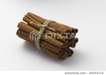 cinnamon sticks tied by rope on white background, healthy eating, copy space, horizontal 84854118