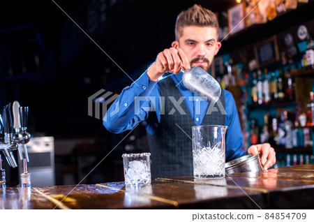 Barman formulates a cocktail on the pothouse Barman formulates a cocktail on the pothouse 84854709