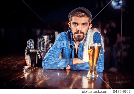 Confident tapster intensely finishes his creation in cocktail bars 84854901