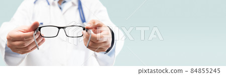 Optometrist holds glasses to try on Optometrist holds glasses to try on 84855245