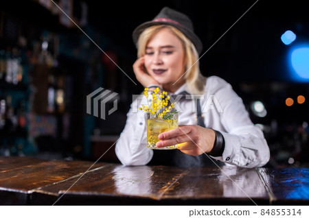Confident girl bartending decorates colorful concoction in the night club Confident girl bartending decorates colorful concoction in the night club 84855314