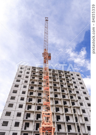 Construction cranes and buildings on a background cloudy sky Construction cranes and buildings on a background cloudy sky 84855339