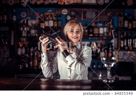 Girl barman mixes a cocktail in the taproom Girl barman mixes a cocktail in the taproom 84855349