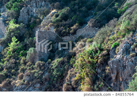 ruins of fortress walls on rocky mountain slopes near the ancient city of Olympus, Turkey ruins of fortress walls on rocky mountain slopes near the ancient city of Olympus, Turkey 84855764