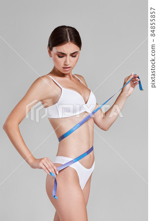 female perfect body in white underwear with measuring tape. 84855857