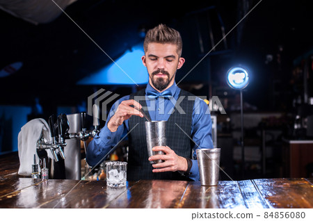 Barman formulates a cocktail at the porterhouse Barman formulates a cocktail at the porterhouse 84856080