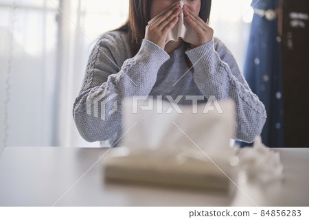 A woman who has a runny nose due to hay fever 84856283