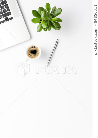 Elegant office desktop with laptop, coffee, pen and small plant. Business background Elegant office desktop with laptop, coffee, pen and small plant. Business background 84856311