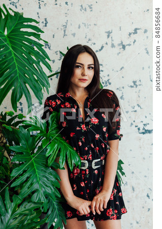 beautiful brunette woman in black dress with flowers 84856684