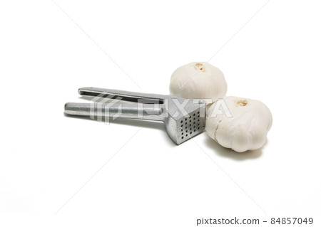 Garlic press and garlic on a white background 84857049