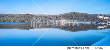 Winter scenery with mountain forests and water reservoir 84858239