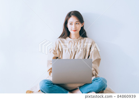 A woman using a personal computer in a room 84860939