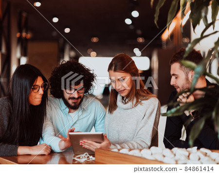 A group of people on a coffee break use laptops, tablets and smartphones while discussing new business projects. business concept. 84861414