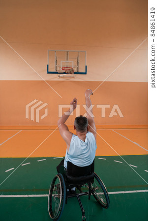 a photo of a person with a disability playing basketball in a modern sports arena. The concept of sport for person with a disability. Selective focus  84861419