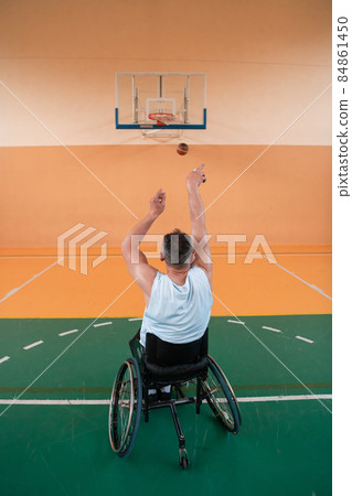 a photo of a person with a disability playing basketball in a modern sports arena. The concept of sport for person with a disability. Selective focus  84861450