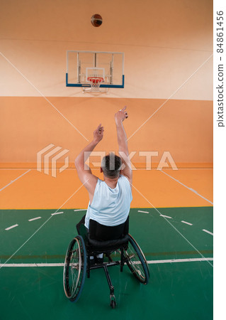 a photo of a person with a disability playing basketball in a modern sports arena. The concept of sport for person with a disability. Selective focus a photo of a person with a disability playing basketball in a modern sports arena. The concept of sport for person with a disability. Selective focus 84861456
