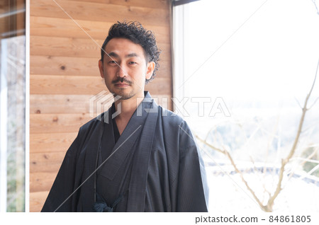 A portrait of a bearded Japanese man who looks good in a kimono looking into the distance 84861805