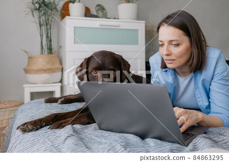 happy european woman and her labrador retriever dog at home 84863295