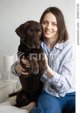 a beautiful portrait of a happy European woman and her dog labrador retriever home office 84863356