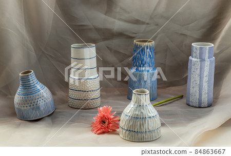 Five Blue and White handmade ceramic vase with Pink flower on Blush textured table cloth. Five Blue and White handmade ceramic vase with Pink flower on Blush textured table cloth. 84863667