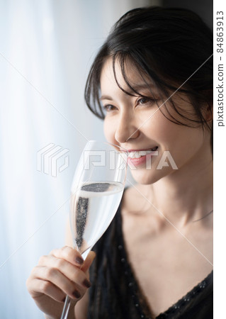 A woman drinking champagne A woman drinking champagne 84863913