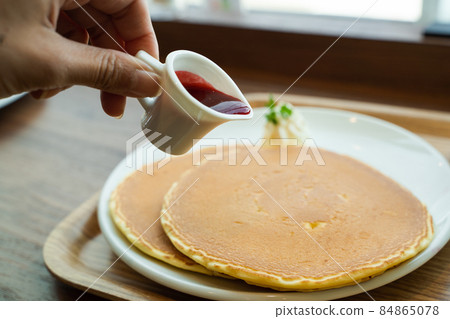 Pour syrup into dessert pancakes Pour syrup into dessert pancakes 84865078