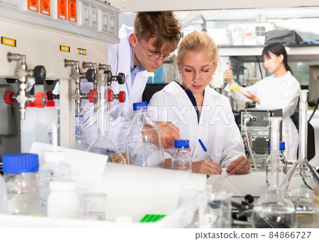 Scientists in white coats working at laboratory 84866727