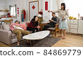angry asian mother hitting father and scolding her lazy adult children who are watching tv and napping. woman complaining with gesture while cleaning house. translation: spring and congratulations 84869779