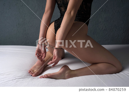 Sexual bdsm toy. Woman with hands tied.  84870259