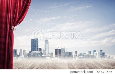 Business city in gray fog behind red curtain and hand holding it Business city in gray fog behind red curtain and hand holding it 84870376
