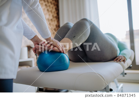 Close up hands of physiotherapist woman exercising with unrecognizable overweight woman indoors in rehabilitation center Close up hands of physiotherapist woman exercising with unrecognizable overweight woman indoors in rehabilitation center 84871345