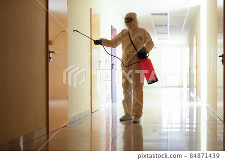 A man sprays a wall of a building from a balloon A man sprays a wall of a building from a balloon 84871439