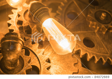 Steampunk architectural style design element of interior.Lamp bulbs fixed on iron industrial gear cogwheels sprocket lighting illuminated equipment Steampunk architectural style design element of interior.Lamp bulbs fixed on iron industrial gear cogwheels sprocket lighting illuminated equipment 84872669