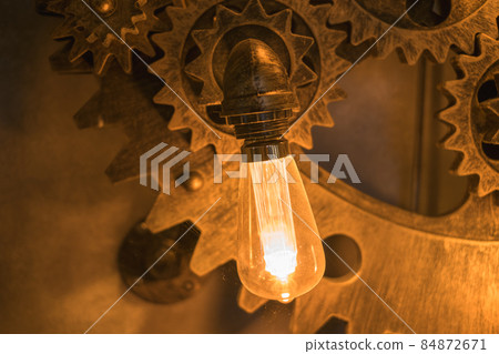 Steampunk architectural style design element of interior.Lamp bulbs fixed on iron industrial gear cogwheels sprocket lighting illuminated equipment Steampunk architectural style design element of interior.Lamp bulbs fixed on iron industrial gear cogwheels sprocket lighting illuminated equipment 84872671