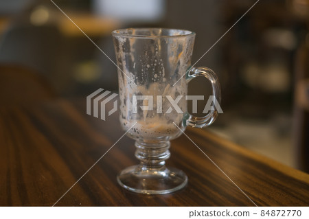 Empty latte glass cup on the table in coffee shop. High quality photo Empty latte glass cup on the table in coffee shop. High quality photo 84872770