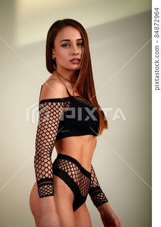 Young girl in black underwear with an ideal body, posing in the studio. Young woman with a beautiful and healthy body. Sexy woman with a perfect body. 84872964
