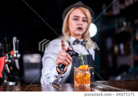 Girl bartender mixes a cocktail in the bar Girl bartender mixes a cocktail in the bar 84873171