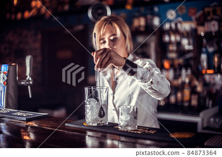 Girl barman formulates a cocktail on the beerhouse Girl barman formulates a cocktail on the beerhouse 84873364
