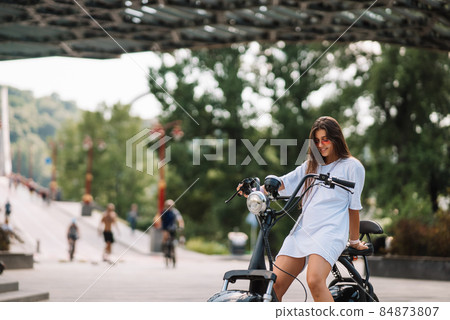 Young beautiful woman and an electric scooter, ecological transport 84873807