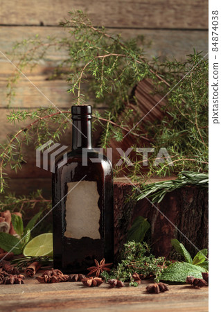 Vintage bottle of gin and various ingredients on an old wooden table. Vintage bottle of gin and various ingredients on an old wooden table. 84874038