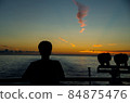Silhouette of a person watching the sunrise from a ship 84875476