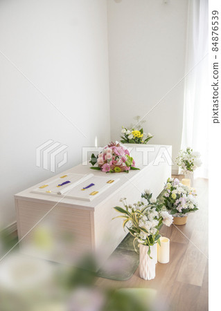 Wooden casket with a bouquet on the casket Home cremation, direct funeral, simple funeral image 84876539
