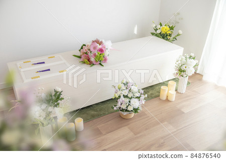 Wooden casket with a bouquet on the casket Home cremation, direct funeral, simple funeral image 84876540