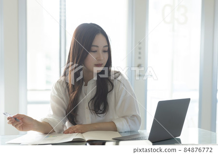 工作在書桌工作的一位小姐 工作在書桌工作的一位小姐 84876772